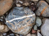 Bläulichgrauer Stein mit verschiedenfarbigen Einschlüssen